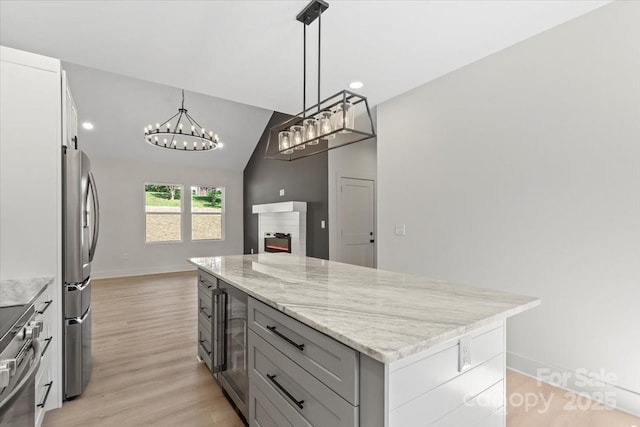 5526 Brookwood Ln, Hickory, NC 28602 - kitchen featuring stainless steel appliances, beverage cooler, light stone countertops, open floor plan, and light wood finished floors