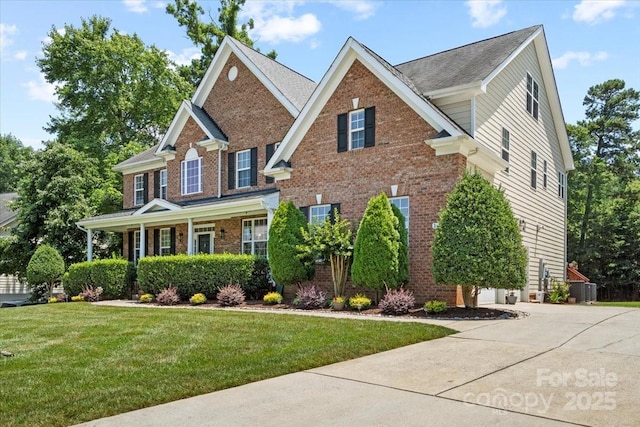 110 Isle Run Dr, Mooresville, NC 28117 - view of front of home featuring brick siding, a front yard, driveway, and covered porch
