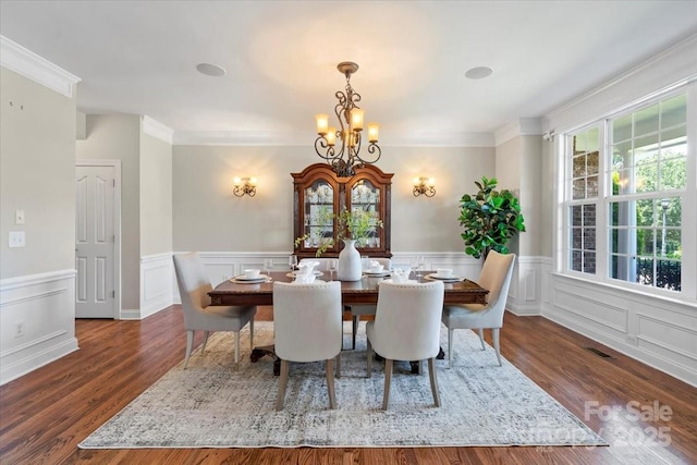 110 Isle Run Dr, Mooresville, NC 28117 - dining area featuring a chandelier, crown molding, wainscoting, a decorative wall, and wood finished floors