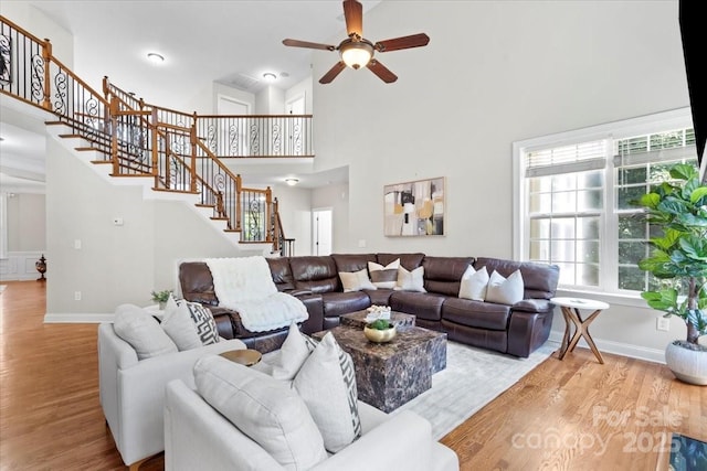 110 Isle Run Dr, Mooresville, NC 28117 - living area with wood finished floors, ceiling fan, a high ceiling, and stairs