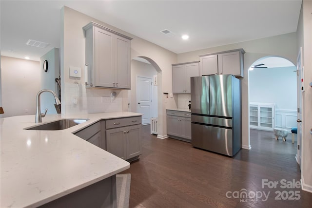334 Kennerly Center Dr, Mooresville, NC 28115 - kitchen featuring freestanding refrigerator, arched walkways, gray cabinetry, a peninsula, and tasteful backsplash