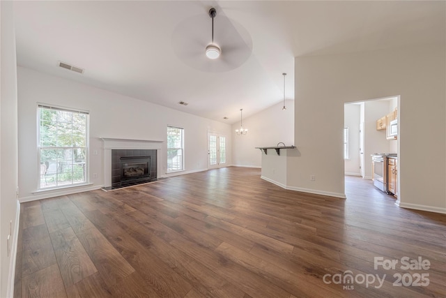 901 Clearbrook Rd, Matthews, NC 28105 - unfurnished living room with ceiling fan, lofted ceiling, dark wood finished floors, healthy amount of natural light, and a tiled fireplace
