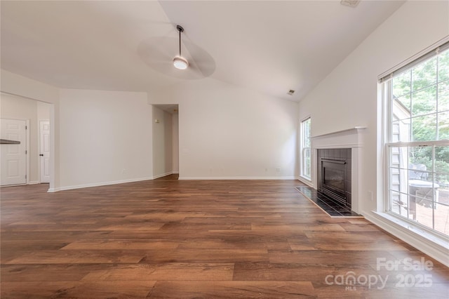 901 Clearbrook Rd, Matthews, NC 28105 - unfurnished living room with healthy amount of natural light, ceiling fan, lofted ceiling, dark wood-type flooring, and a tiled fireplace