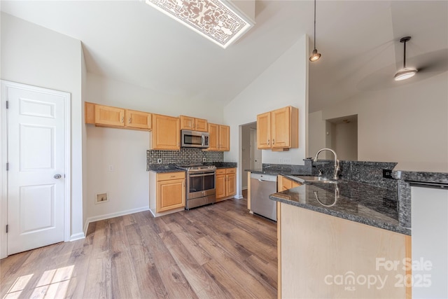 901 Clearbrook Rd, Matthews, NC 28105 - kitchen with a peninsula, light brown cabinets, appliances with stainless steel finishes, wood finished floors, and high vaulted ceiling