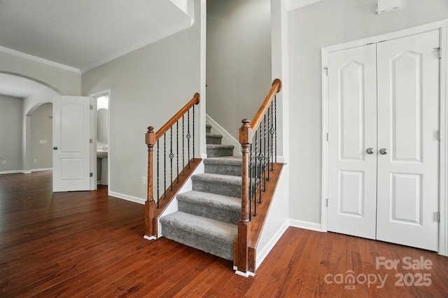 8115 Kelburn Ln, Charlotte, NC 28273 - staircase with arched walkways, ornamental molding, and hardwood / wood-style flooring