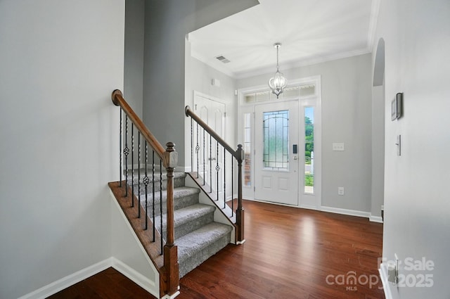 8115 Kelburn Ln, Charlotte, NC 28273 - foyer entrance featuring dark wood-style flooring, crown molding, and stairs