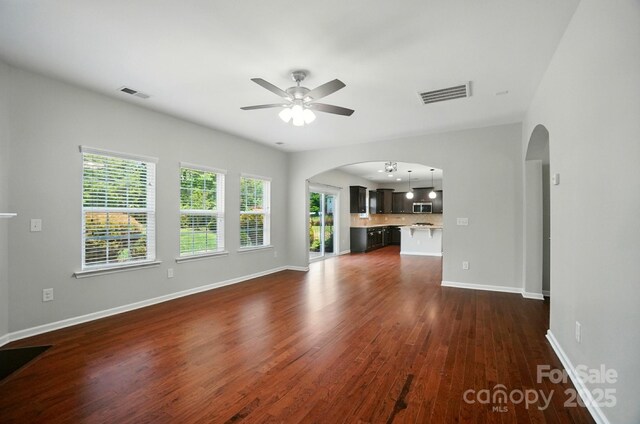 8115 Kelburn Ln, Charlotte, NC 28273 - unfurnished living room with arched walkways, a ceiling fan, and dark wood-style floors
