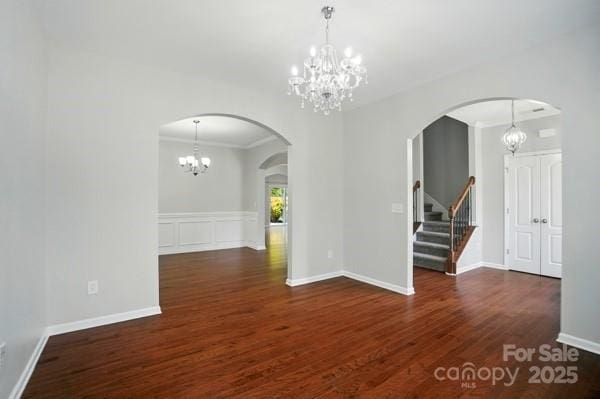 8115 Kelburn Ln, Charlotte, NC 28273 - spare room with a chandelier, wood finished floors, stairs, arched walkways, and ornamental molding