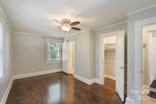 115 E Catawba St, Morganton, NC 28655 - unfurnished bedroom with wood finished floors, ceiling fan, ornamental molding, and a walk in closet