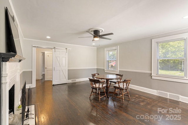 115 E Catawba St, Morganton, NC 28655 - dining area with a barn door, ceiling fan, crown molding, wood finished floors, and a premium fireplace