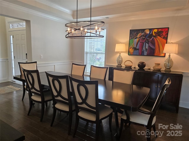 5000 Britannia Blvd, Waxhaw, NC 28173 - dining space featuring a tray ceiling, dark wood-type flooring, a chandelier, a decorative wall, and wainscoting