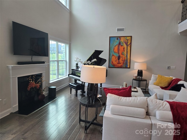 5000 Britannia Blvd, Waxhaw, NC 28173 - living room with healthy amount of natural light, a high ceiling, wood finished floors, a fireplace with raised hearth, and baseboards