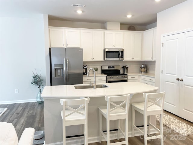 8060 Scarlet Maple Ln, Tega Cay, SC 29708 - kitchen featuring stainless steel appliances, a breakfast bar, tasteful backsplash, white cabinetry, and recessed lighting