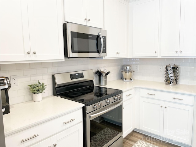 8060 Scarlet Maple Ln, Tega Cay, SC 29708 - kitchen featuring appliances with stainless steel finishes, white cabinetry, and tasteful backsplash