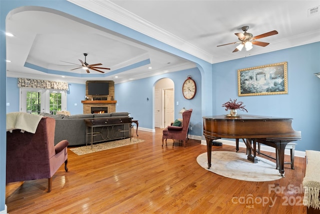 1912 Dawnhurst Ln, York, SC 29745 - living room featuring ceiling fan, arched walkways, light wood finished floors, a large fireplace, and crown molding