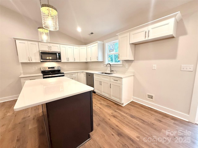 2330 Neill Rd, Lancaster, SC 29720 - kitchen featuring appliances with stainless steel finishes, white cabinets, vaulted ceiling, and light wood-style floors