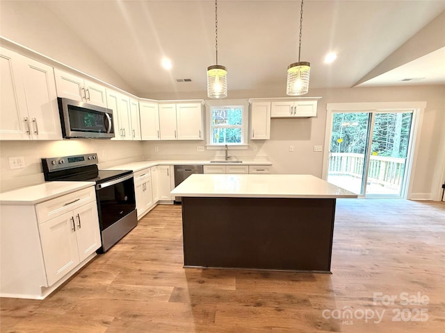 2330 Neill Rd, Lancaster, SC 29720 - kitchen featuring appliances with stainless steel finishes, lofted ceiling, a kitchen island, white cabinets, and light countertops