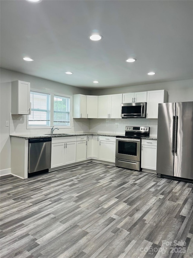 1535 Jordan St, Lancaster, SC 29720 - kitchen featuring stainless steel appliances, light wood-style floors, backsplash, white cabinets, and recessed lighting
