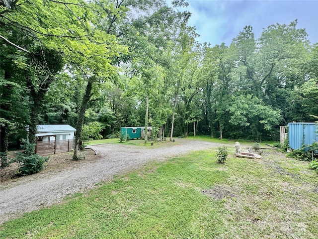 401 Church St, Warrenton, NC 27589 - view of grassy yard featuring a storage shed, driveway, and a view of trees