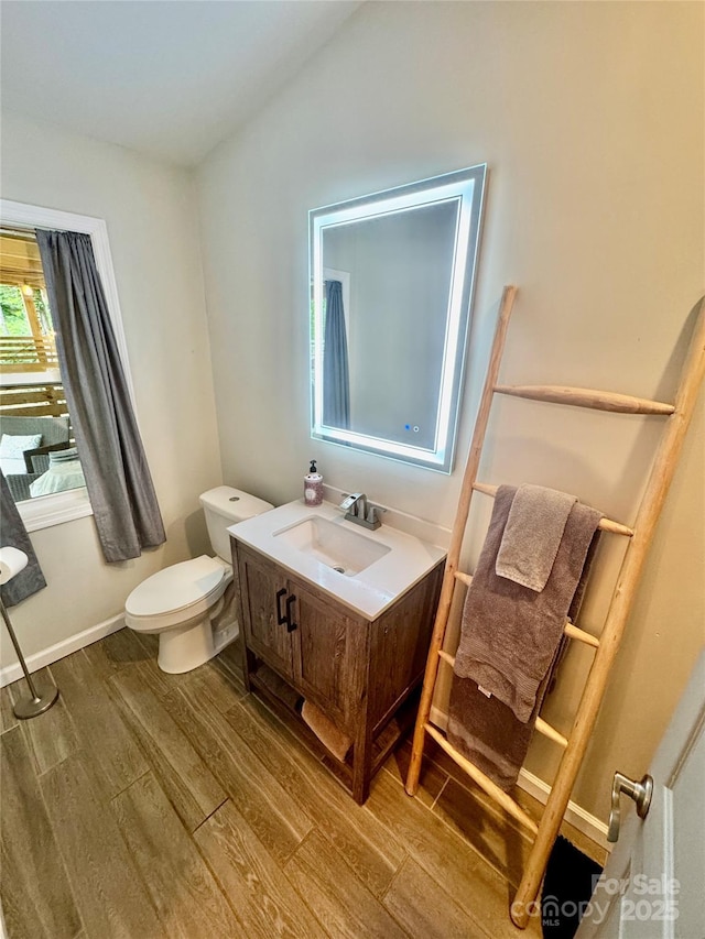 401 Church St, Warrenton, NC 27589 - bathroom featuring wood finished floors, vanity, and vaulted ceiling