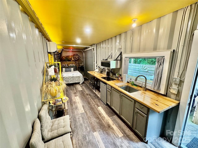 401 Church St, Warrenton, NC 27589 - kitchen featuring butcher block counters, dark wood-style floors, gray cabinetry, and stainless steel dishwasher