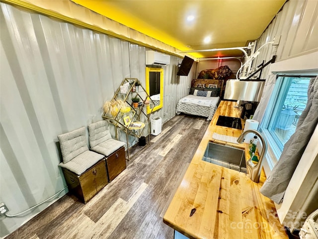 401 Church St, Warrenton, NC 27589 - bedroom with an AC wall unit and wood finished floors