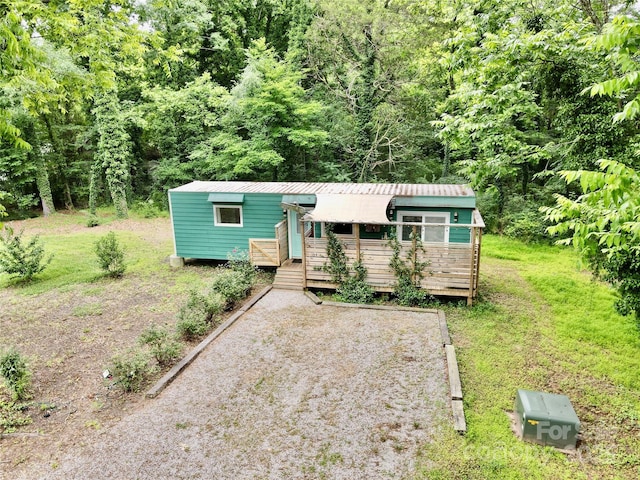 401 Church St, Warrenton, NC 27589 - view of front of property featuring a deck, a metal roof, and a wooded view