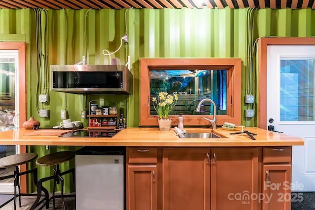 401 Church St, Warrenton, NC 27589 - kitchen featuring stainless steel microwave, butcher block counters, and black electric stovetop