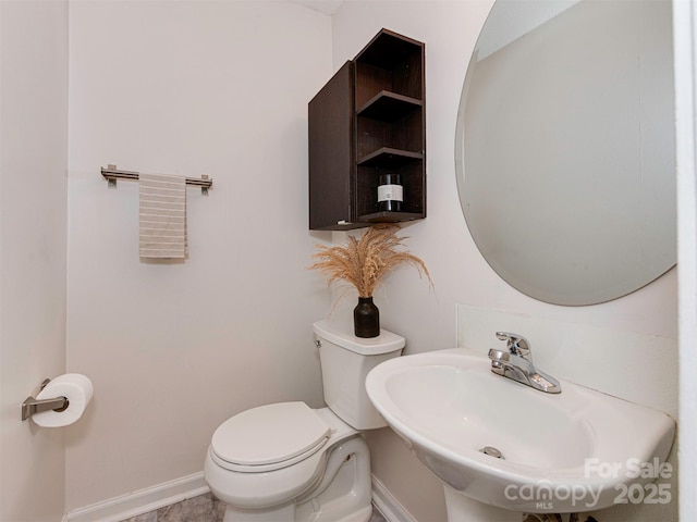 713 Springfield Dr NW, Concord, NC 28027 - bathroom with baseboards, toilet, and a sink