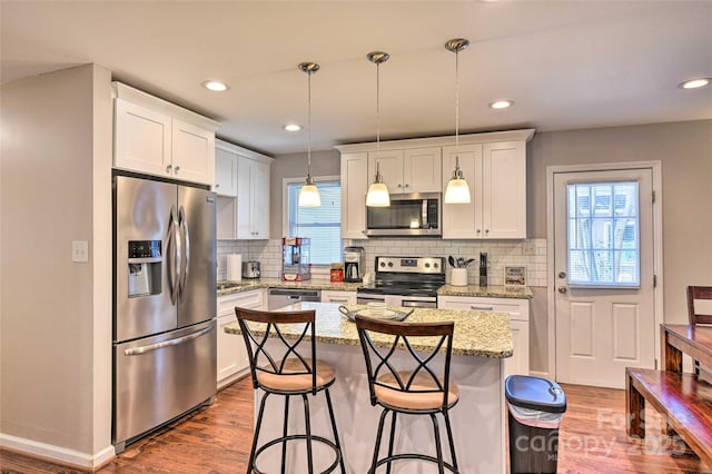 3020 Stancill Pl, Charlotte, NC 28205 - kitchen with appliances with stainless steel finishes, dark wood-style floors, tasteful backsplash, a center island, and recessed lighting