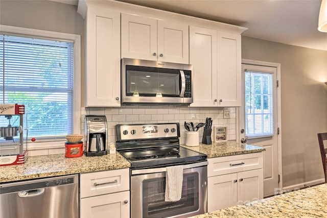 3020 Stancill Pl, Charlotte, NC 28205 - kitchen with appliances with stainless steel finishes, backsplash, white cabinetry, and light stone countertops