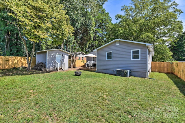 3020 Stancill Pl, Charlotte, NC 28205 - rear view of house with central AC unit, a fire pit, an outbuilding, and view of scattered trees