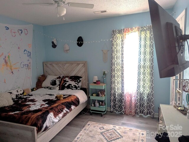 5077 Edney Ct, Granite Falls, NC 28630 - bedroom with light wood finished floors, ceiling fan, and a textured ceiling