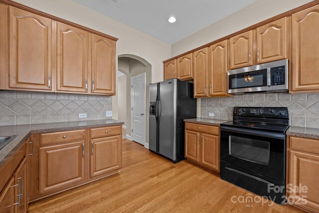 10349 Alvarado Way, Charlotte, NC 28277 - kitchen featuring appliances with stainless steel finishes, light wood-type flooring, arched walkways, decorative backsplash, and recessed lighting
