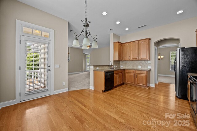 10349 Alvarado Way, Charlotte, NC 28277 - kitchen featuring dishwasher, a chandelier, light wood-type flooring, freestanding refrigerator, and arched walkways