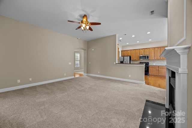 10349 Alvarado Way, Charlotte, NC 28277 - unfurnished living room with a ceiling fan, light colored carpet, a fireplace with flush hearth, recessed lighting, and arched walkways