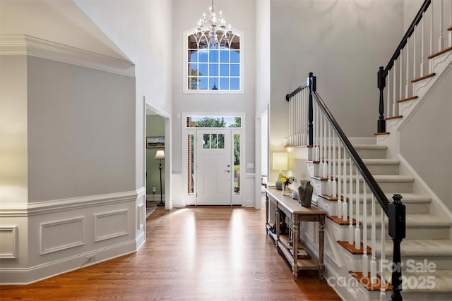 12644 Lahinch Ct, Charlotte, NC 28277 - foyer featuring a high ceiling, wood finished floors, stairs, a chandelier, and wainscoting