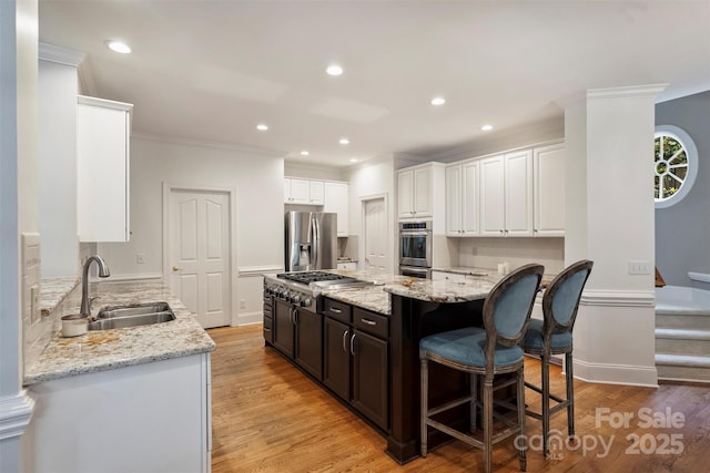 12644 Lahinch Ct, Charlotte, NC 28277 - kitchen with stainless steel appliances, a kitchen island, light stone countertops, white cabinets, and a breakfast bar