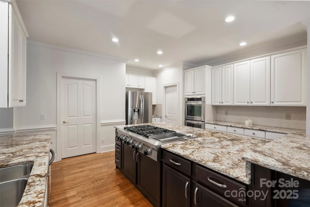 12644 Lahinch Ct, Charlotte, NC 28277 - kitchen featuring stainless steel appliances, crown molding, white cabinets, light stone counters, and light wood finished floors