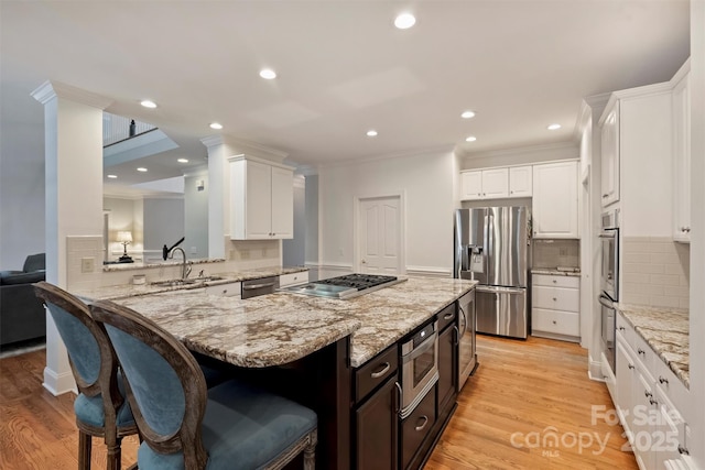 12644 Lahinch Ct, Charlotte, NC 28277 - kitchen featuring stainless steel appliances, a kitchen bar, ornamental molding, white cabinetry, and backsplash