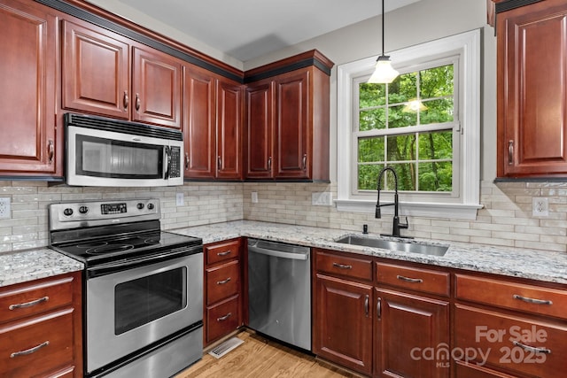 17433 Glassfield Dr, Huntersville, NC 28078 - kitchen featuring stainless steel appliances, light wood finished floors, tasteful backsplash, and pendant lighting