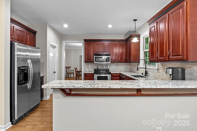 17433 Glassfield Dr, Huntersville, NC 28078 - kitchen with appliances with stainless steel finishes, decorative backsplash, light wood-style floors, a peninsula, and hanging light fixtures