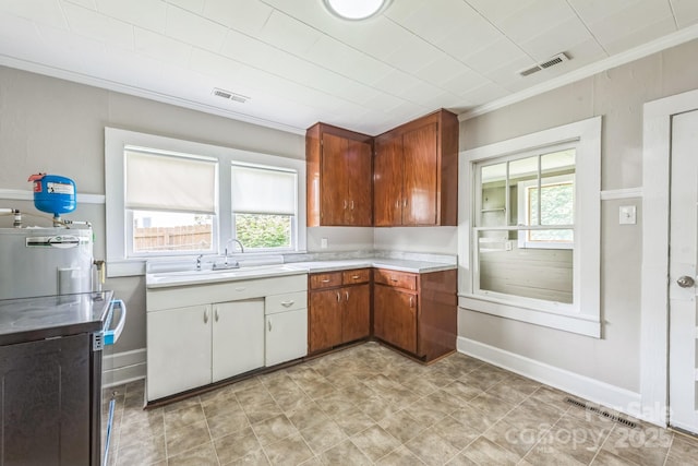 807 3rd St, Kings Mountain, NC 28086 - kitchen featuring ornamental molding, light countertops, healthy amount of natural light, water heater, and stainless steel range oven