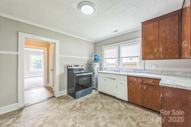 807 3rd St, Kings Mountain, NC 28086 - kitchen with stainless steel electric range, electric water heater, light countertops, and ornamental molding