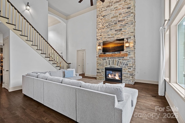 109 Walking Horse Trl, Davidson, NC 28036 - living area featuring a fireplace, ornamental molding, a ceiling fan, dark wood-style floors, and a towering ceiling