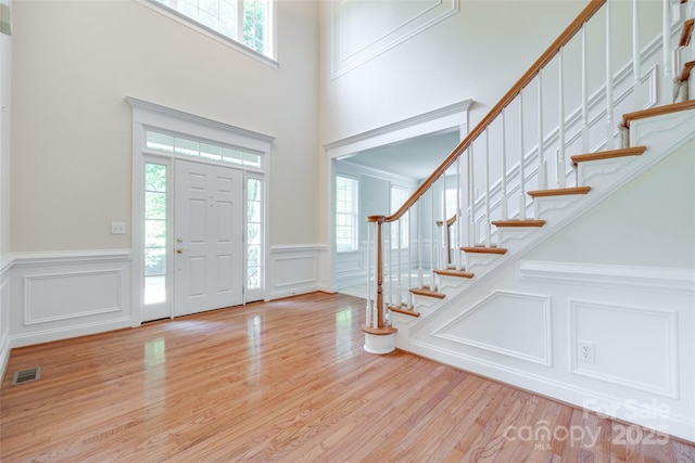 5008 Woodview Ln, Weddington, NC 28104 - entrance foyer with a decorative wall, wainscoting, stairs, wood finished floors, and a towering ceiling