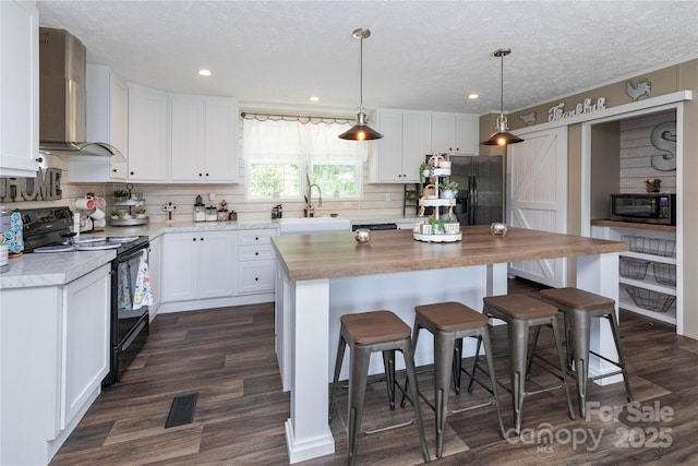 600 Old Mars Hill Hwy, Weaverville, NC 28787 - kitchen featuring black appliances, wall chimney range hood, decorative backsplash, a textured ceiling, and white cabinetry