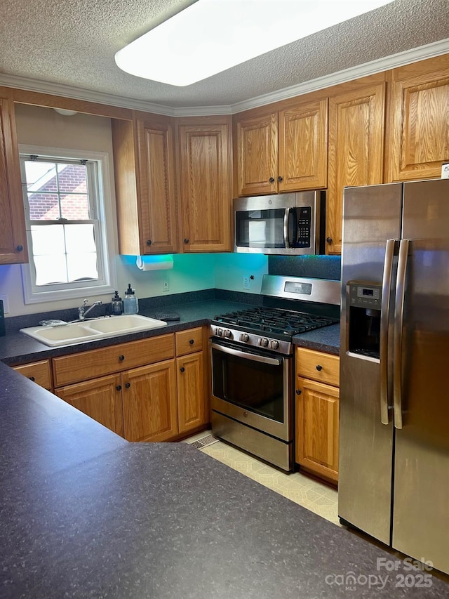 1700 Pickwick Ave, Kannapolis, NC 28083 - kitchen featuring appliances with stainless steel finishes, a sink, brown cabinetry, dark countertops, and crown molding