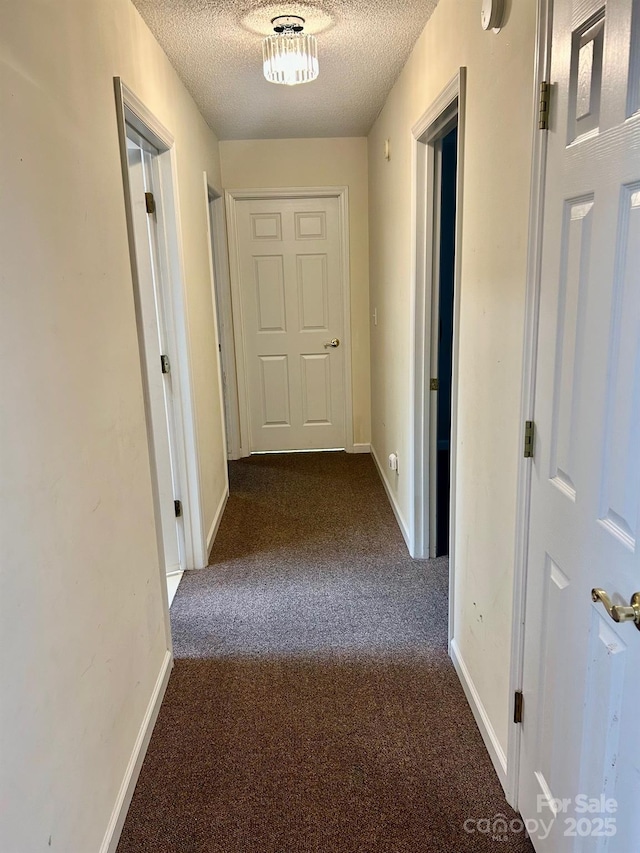 1700 Pickwick Ave, Kannapolis, NC 28083 - hallway with dark carpet, a textured ceiling, and baseboards