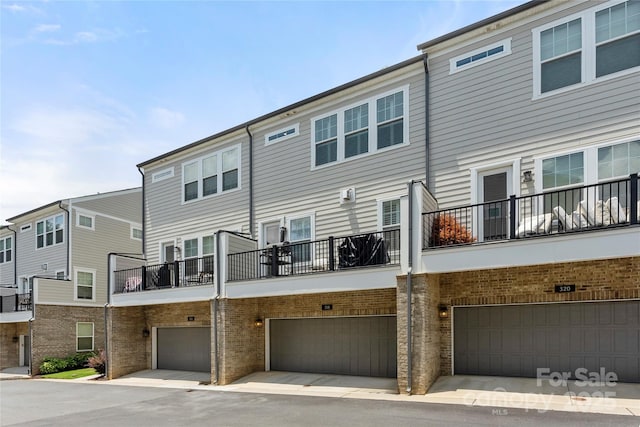 318 N Dotger Ave, Charlotte, NC 28204 - back of house with an attached garage, a balcony, and brick siding